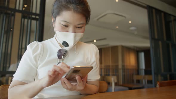 asian female woman wearing face mask protection hand use smartphone