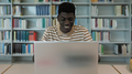 Young African student using laptop in library - School education concept - PhotoDune Item for Sale