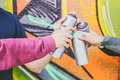 Close up hands of people holding color spray cans against the graffiti wall - PhotoDune Item for Sale