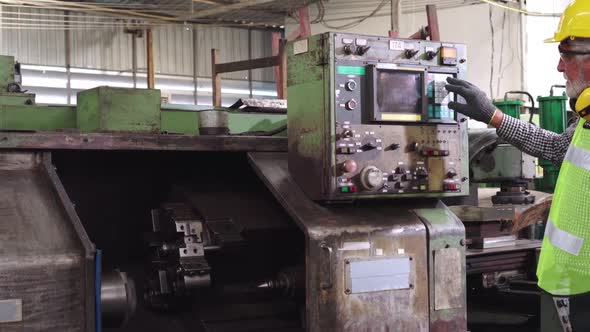 Senior Factory Worker Teach How to Use Machine Equipment in the Factory Workshop