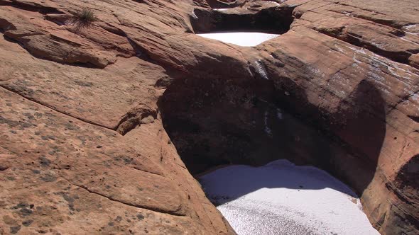 Hiking along frozen pools of water in the desert sandstone