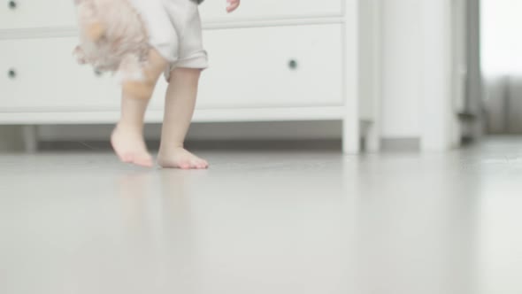 First Steps Closeup View Toddler Baby Legs and Feet Barefoot Walking on Floor