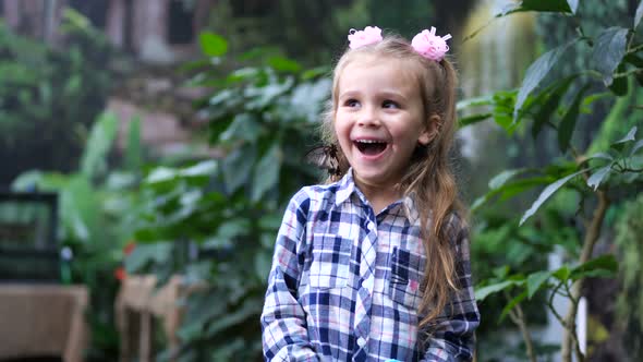 The Little Girl Sincerely Rejoices a Butterfly Pose on Her Head