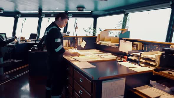 Marine Navigational Officer During Navigational Watch on Bridge . He Does Chart Correction