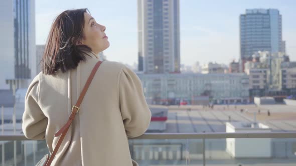 Close-up Back View of Young Caucasian Businesswoman Standing Looking at City Street