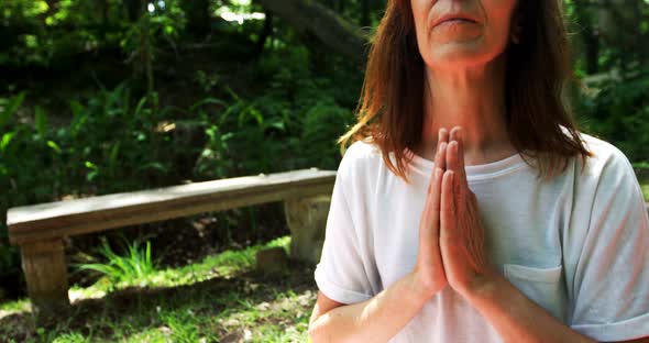 Mature woman performing yoga in the park 4k