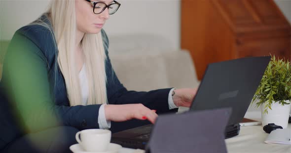 Businesswoman Working on Laptop on a Project at Home Office. Young Woman Using Laptop Computer.