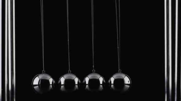 The balls of a Newtons Cradle colliding in slow motion