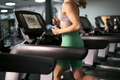 Part of caucasian woman running on treadmill at fitness center - PhotoDune Item for Sale