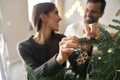 Happy couple decorating Christmas tree at home - PhotoDune Item for Sale