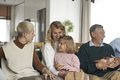 Multi generation caucasian family sitting and holding Christmas presents at home - PhotoDune Item for Sale