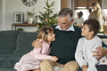 Grandfather and grandchildren bonding on sofa at Christmas time - PhotoDune Item for Sale