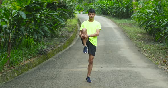 Runner Stretching Legs On Road