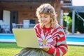 Teenage girl sitting on lawn in backyard, using laptop for studying leisure - PhotoDune Item for Sale