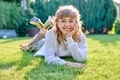 Portrait of cute teenage girl lying on grass looking at camera - PhotoDune Item for Sale