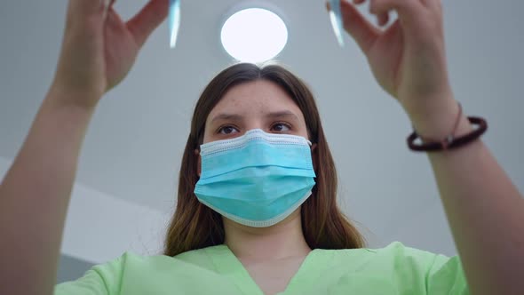 Bottom Angle View of Concentrated Young Lab Technician Examining Test Tubes Leaving