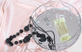 round mirror tray with luxury perfume bottle and female beads and ring on a silk bedding.  - PhotoDune Item for Sale