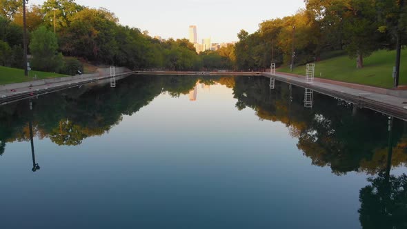 Flying straight down barton springs pool on a perfectly calm day. Downtown Austin TX in the backgrou