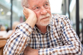 Sad man - handsome bearded elderly man sitting thoughtfully holding his head with hand - PhotoDune Item for Sale