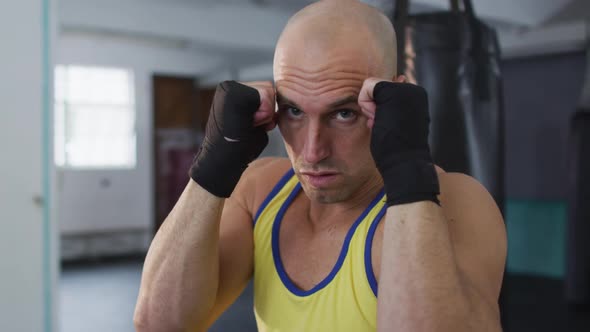 Portrait of caucasian male boxer practicing his punches at the gym