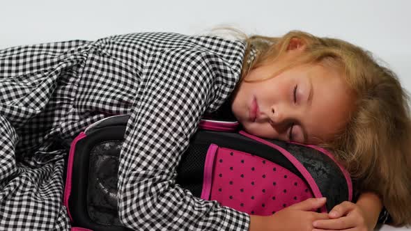 A Student Sleeps Hugging a School Bag