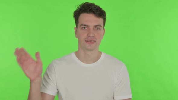 Young Man Waving Welcoming on Green Background