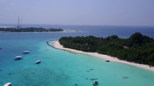 Drone aerial seascape of tourist beach break by blue lagoon with sand background