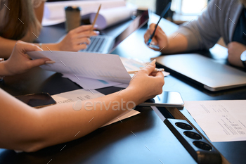 ness document to colleagues seated at office desk