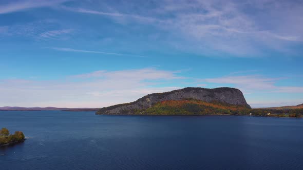 Aerial orbit to right past distant Kineo Mountain over Moosehead Lake in fall