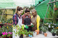 Multiracial gardeners working together in plants and flowers garden shop - PhotoDune Item for Sale
