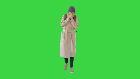 Woman in a Coat Walking and Coughing on a Green Screen, Chroma Key.