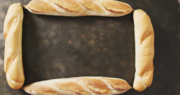 Video of four baguettes forming rectangle on a black surface