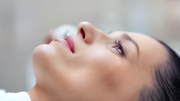 Smiling Beautiful Woman Enjoying Ultrasonic Face Cleansing at Beauty Salon Closeup