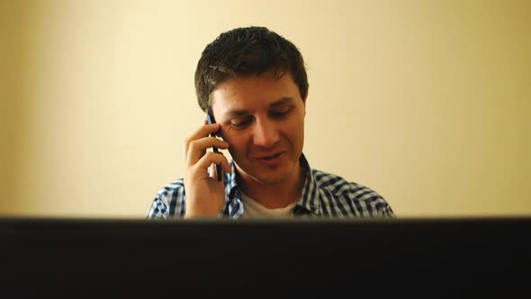 Man Working On A Notebook And Talking On A Phone