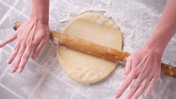 Apple Pie Preparation Series  Woman Rolling Out Dough with Pin on a Table