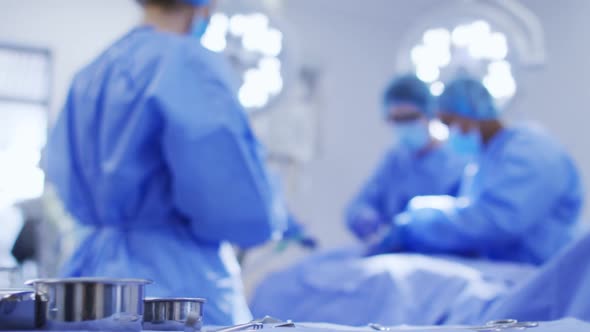 Diverse surgeons wearing surgical caps and face masks in operating theatre in hospital