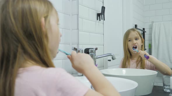 Pre Teen Girl Brushes Her Teeth and Washing His Face in the Bathroom