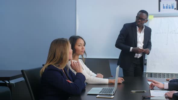 Colleagues Asking a Question To a Businesswoman During a Presentation