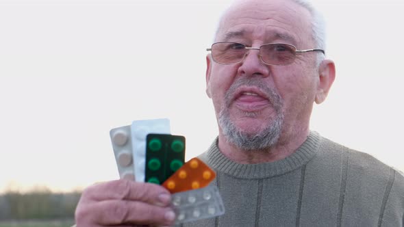 Old Grandfather Holds Various Pills in His Hands