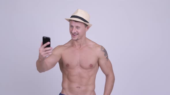 Happy Muscular Bearded Tourist Man Vlogging with Phone Shirtless
