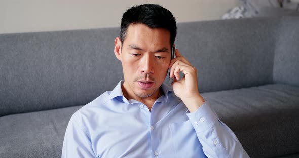 Man talking on mobile phone in living room