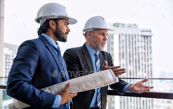 ruction site and discuss with senior engineer for progress of construction project from high rise building