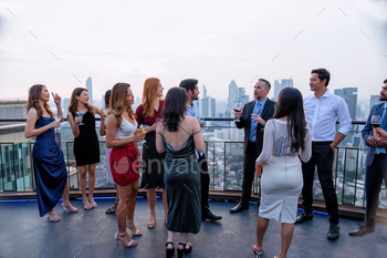invited his team to join the party on the rooftop restaurant they hold a glass of drink wine, ora