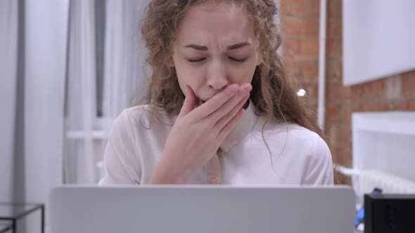 Yawning Tired Female while Working on Laptop in Office