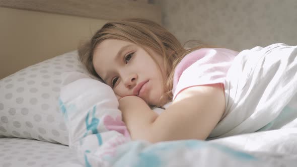 Depression Child Girl Lying Under a Blanket at Home