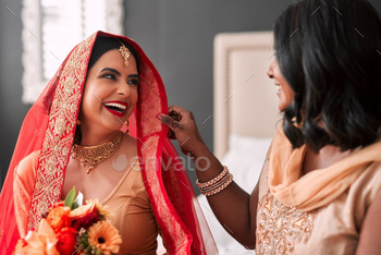Shot of a young woman getting getting ready for her wedding with her bridesmaid
