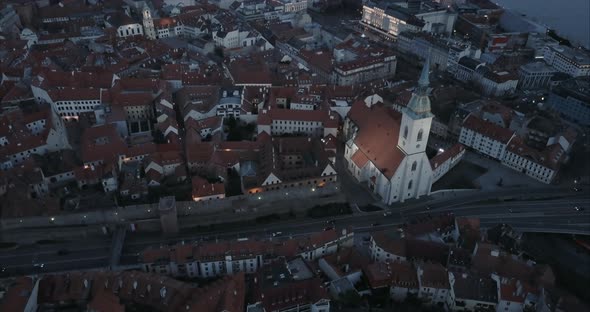 Slow Descending Aerial shot of St. Martin church and Bratislava old town with traffic, twilight