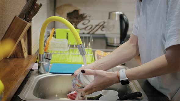 Young Woman Washing Dishes at Home. Female Hand Cleaning Dish Close Up.