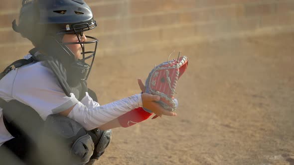 Boy plays catcher in a little league baseball game.