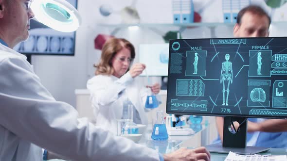 Over the Shoulder Shot of Male Researcher Working at His Desk